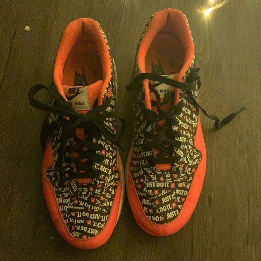 black white and orange nike just do it gym shoes. size 7 in mens and 9 in womens